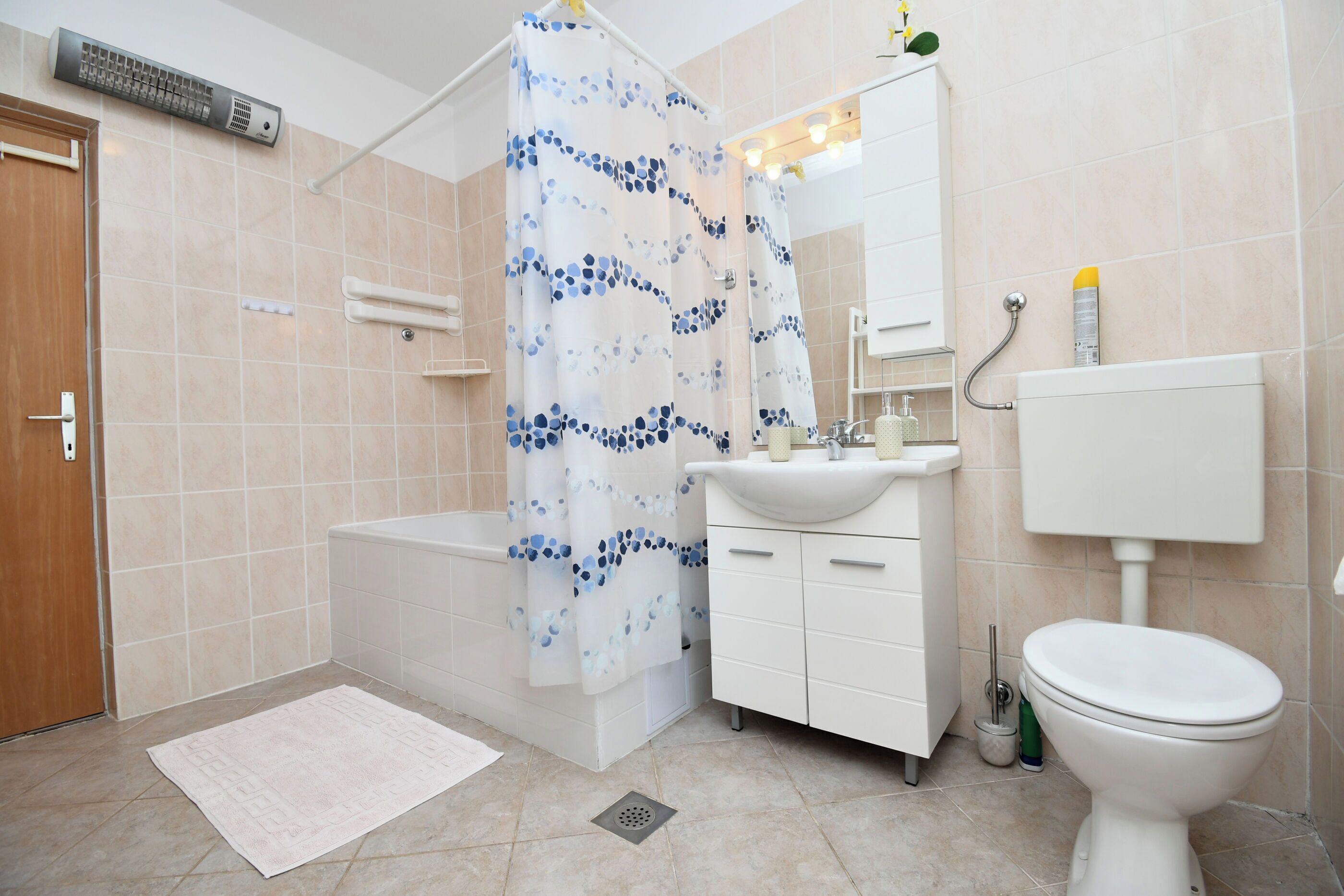 A bathroom with a bathtub, a toilet, a sink, and a shower curtain.
