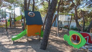 Une aire de jeux avec un toboggan et des structures d’escalade.