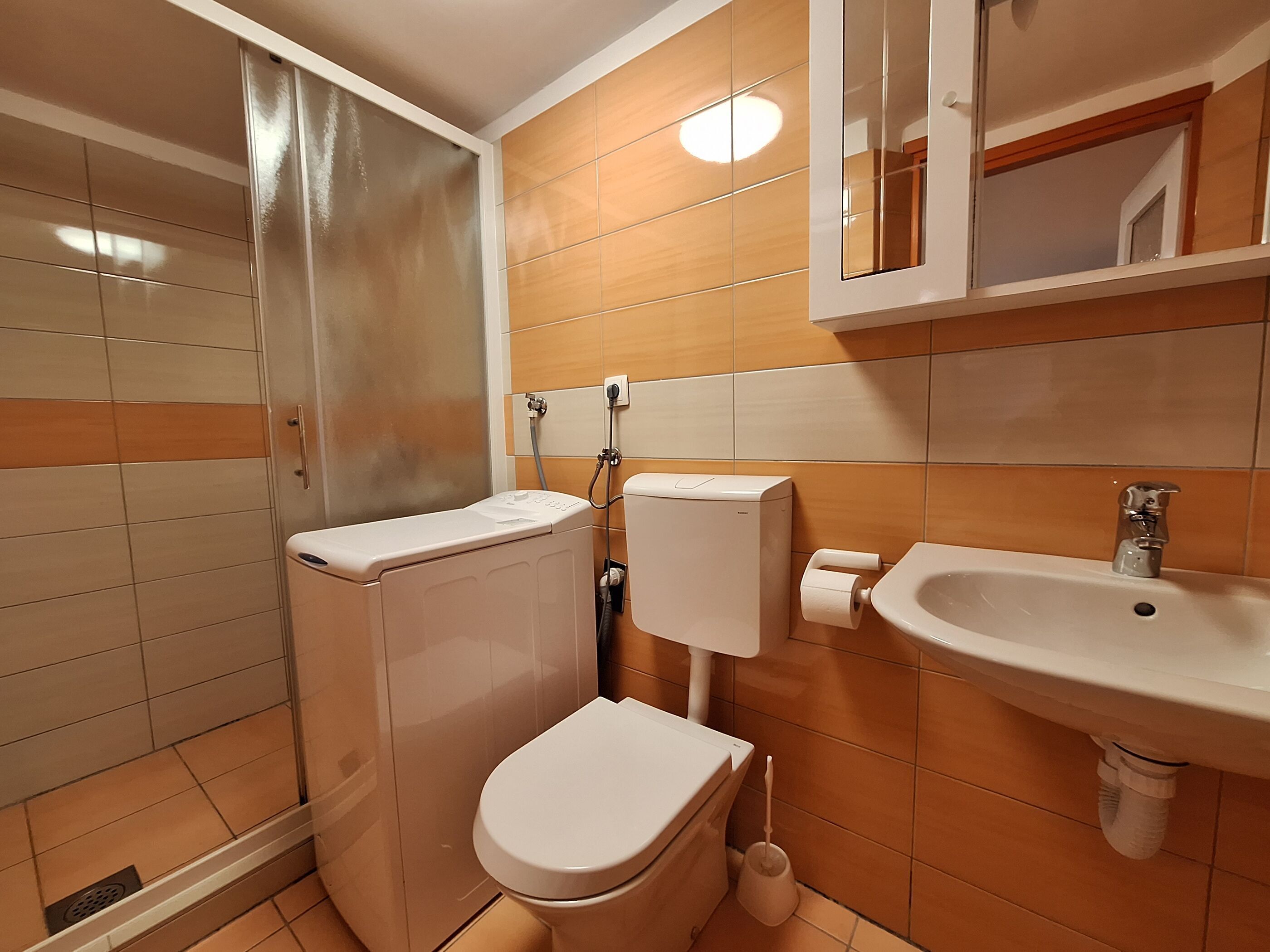 A compact bathroom with a toilet, bidet, and sink.