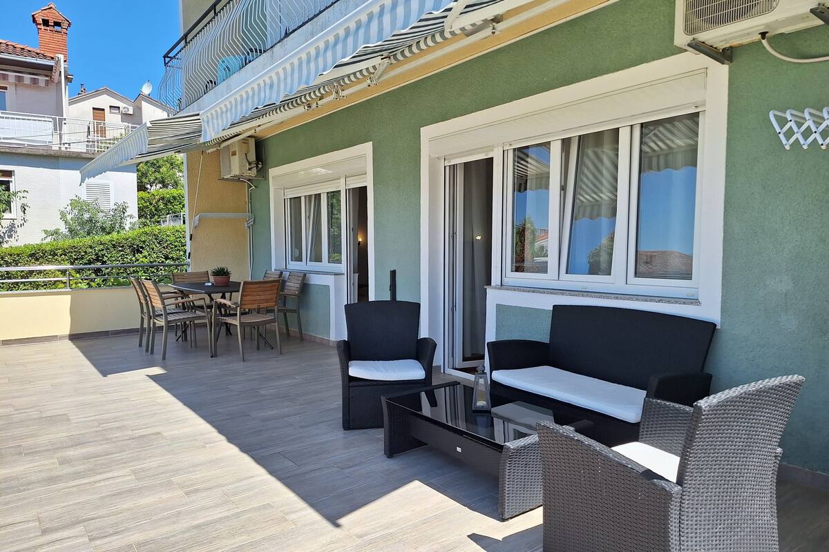 Une terrasse avec des sièges, une table et des chaises.