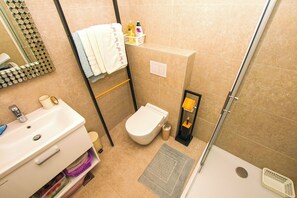 A bathroom with a sink, toilet, and shower. - Apartment Teny (Zadar)