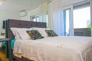 Ein Schlafzimmer mit einem großen Bett, einem Nachttisch und einem Sessel.