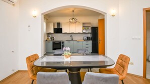 A modern kitchen with grey cabinets, a black refrigerator, and a microwave. - Apartments Smoljic (Trogir)