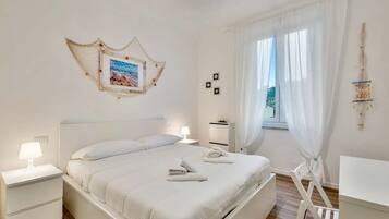 2 dormitorios y tabla de planchar con plancha