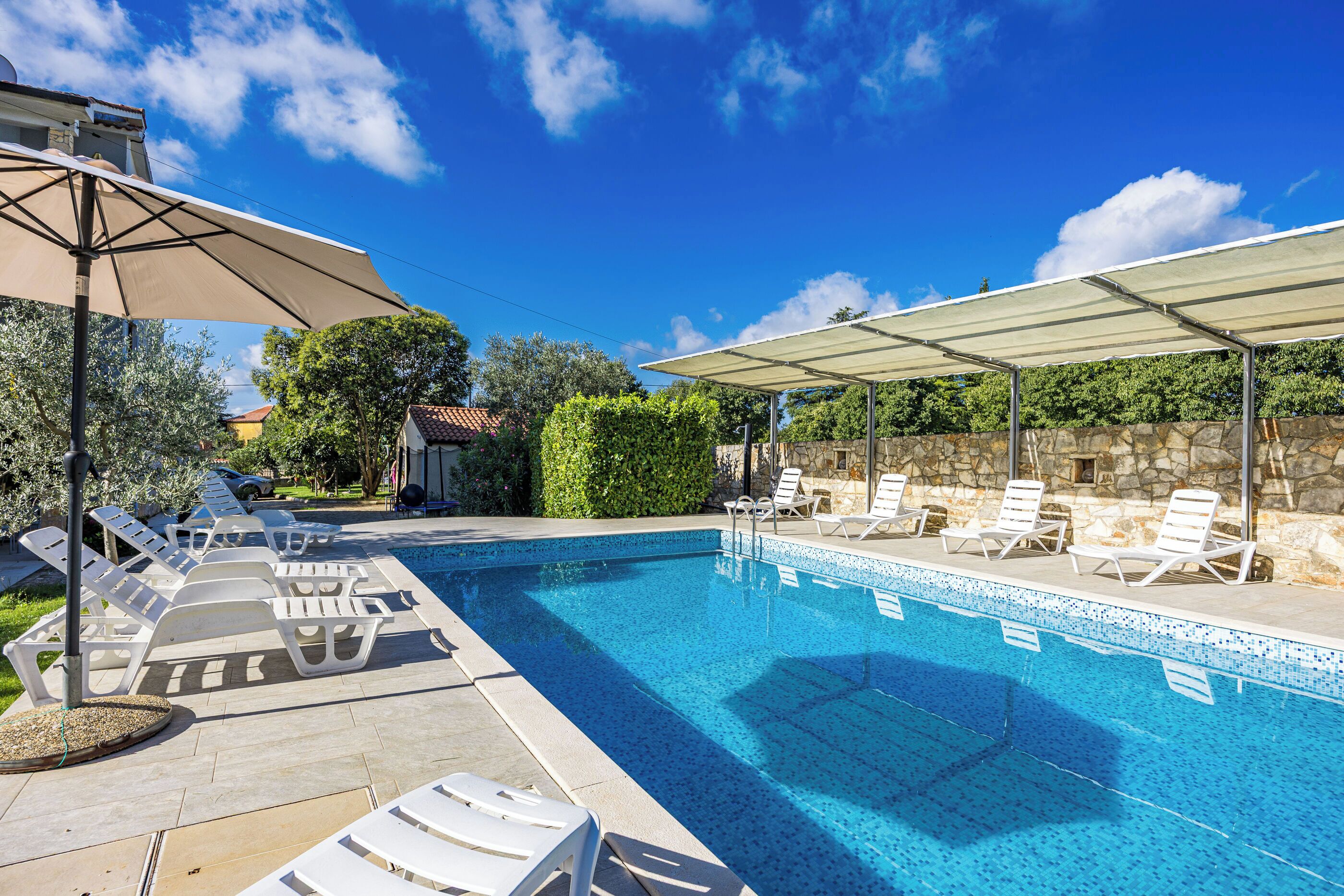 Outdoor pool, an infinity pool, pool umbrellas, pool loungers
