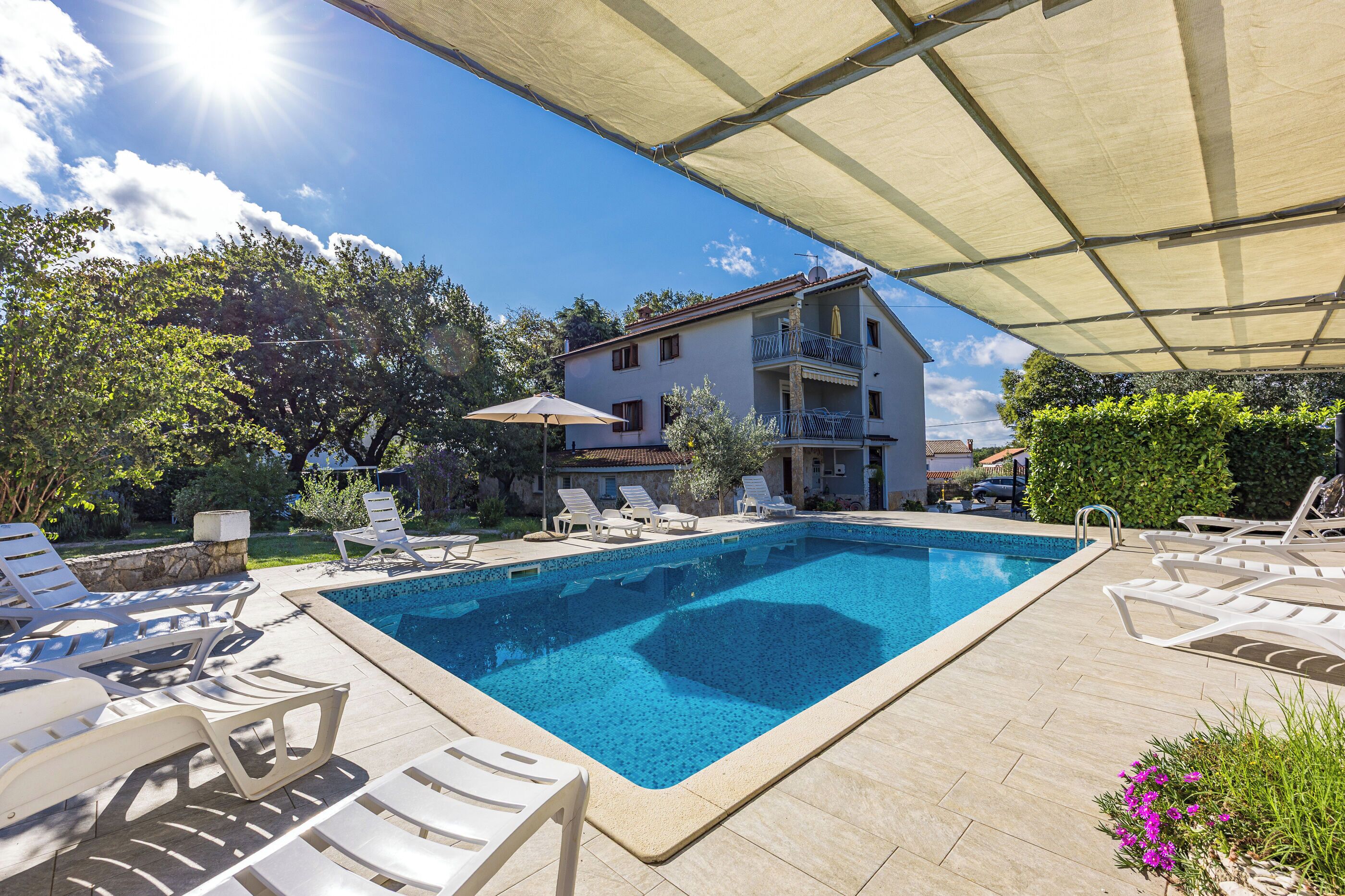 Een buitenzwembad, een infinity pool, parasols voor strand/zwembad