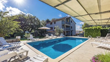 Een buitenzwembad, een infinity pool, parasols voor strand/zwembad
