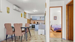 A compact living space with a dining area, kitchenette, and a bedroom. - Apartment Tin (Medulin)