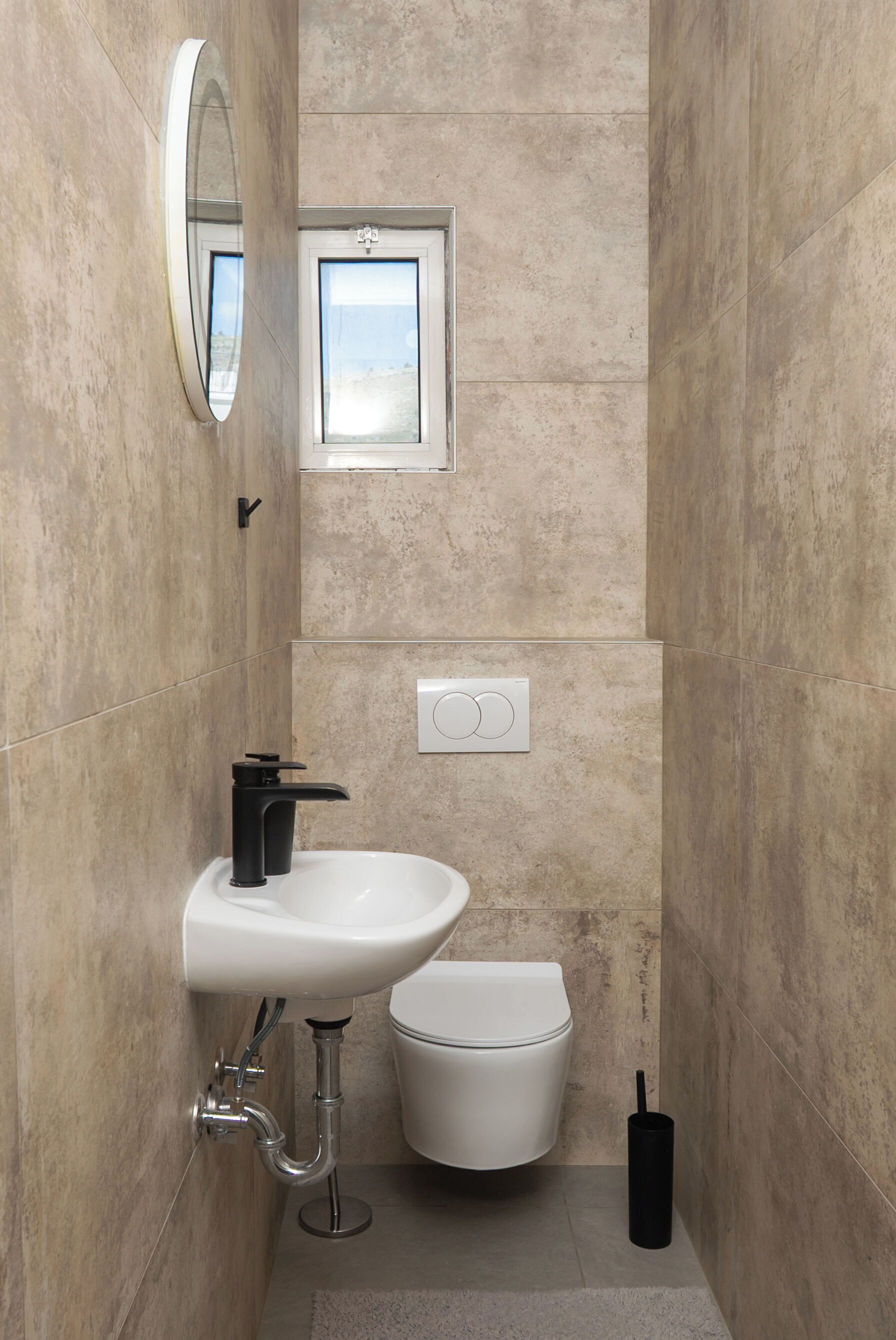 A bathroom with a white sink, toilet, and a mirror.
