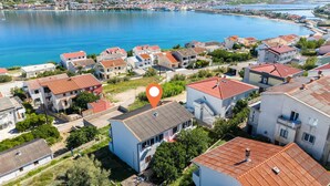 A residential area with houses, a body of water, and a location marker. - Apartments Bepo i Marija Pag (Pag)