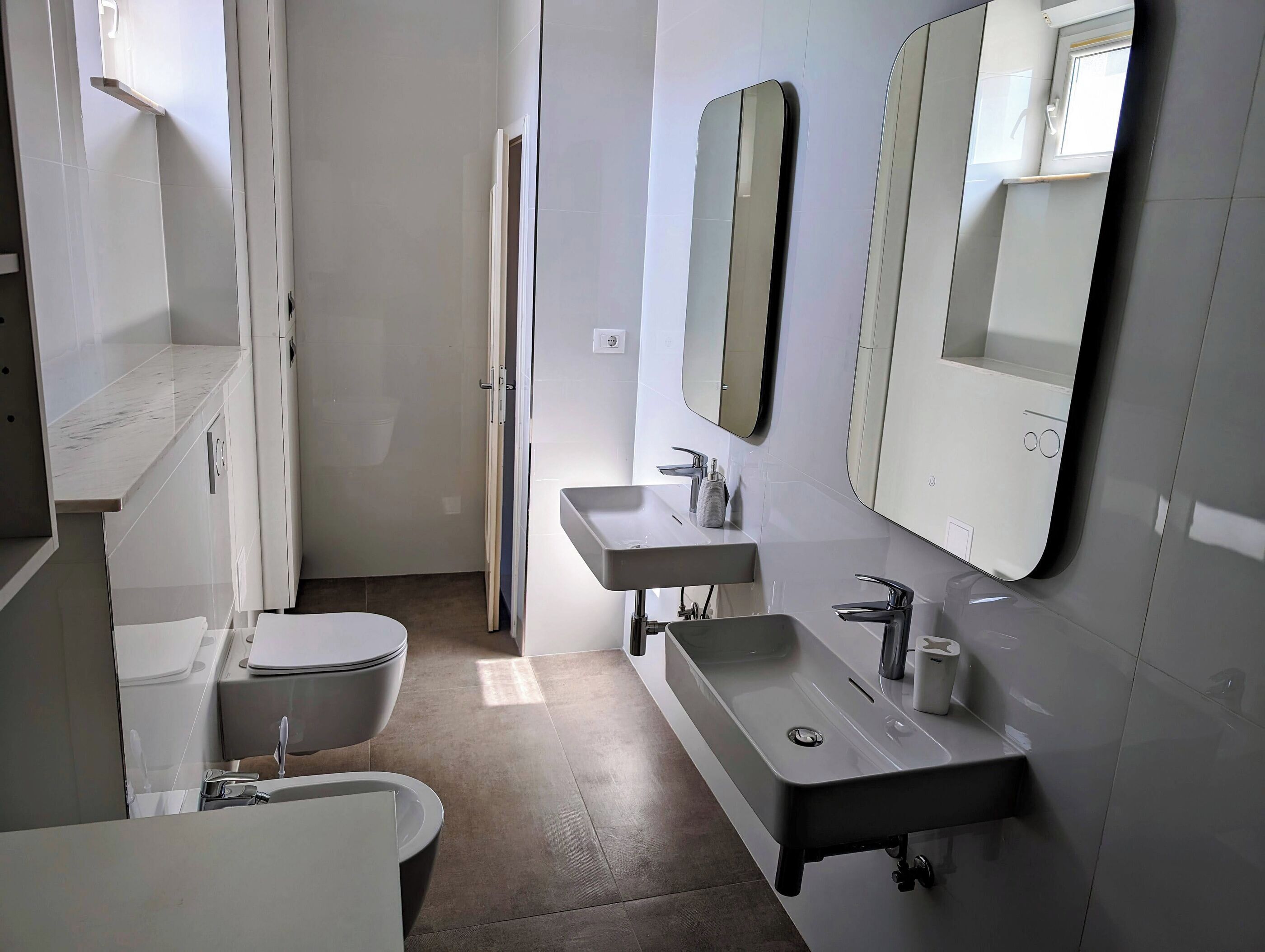 Une salle de bain moderne équipée de toilettes, d’un lavabo et d’un miroir.