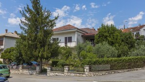 Une rue résidentielle bordée de maisons, avec un passage piéton et des voitures garées.
