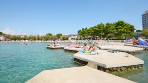 A public swimming area with multiple platforms and people swimming and relaxing. - Apartment Rose Garden (Rovinj)