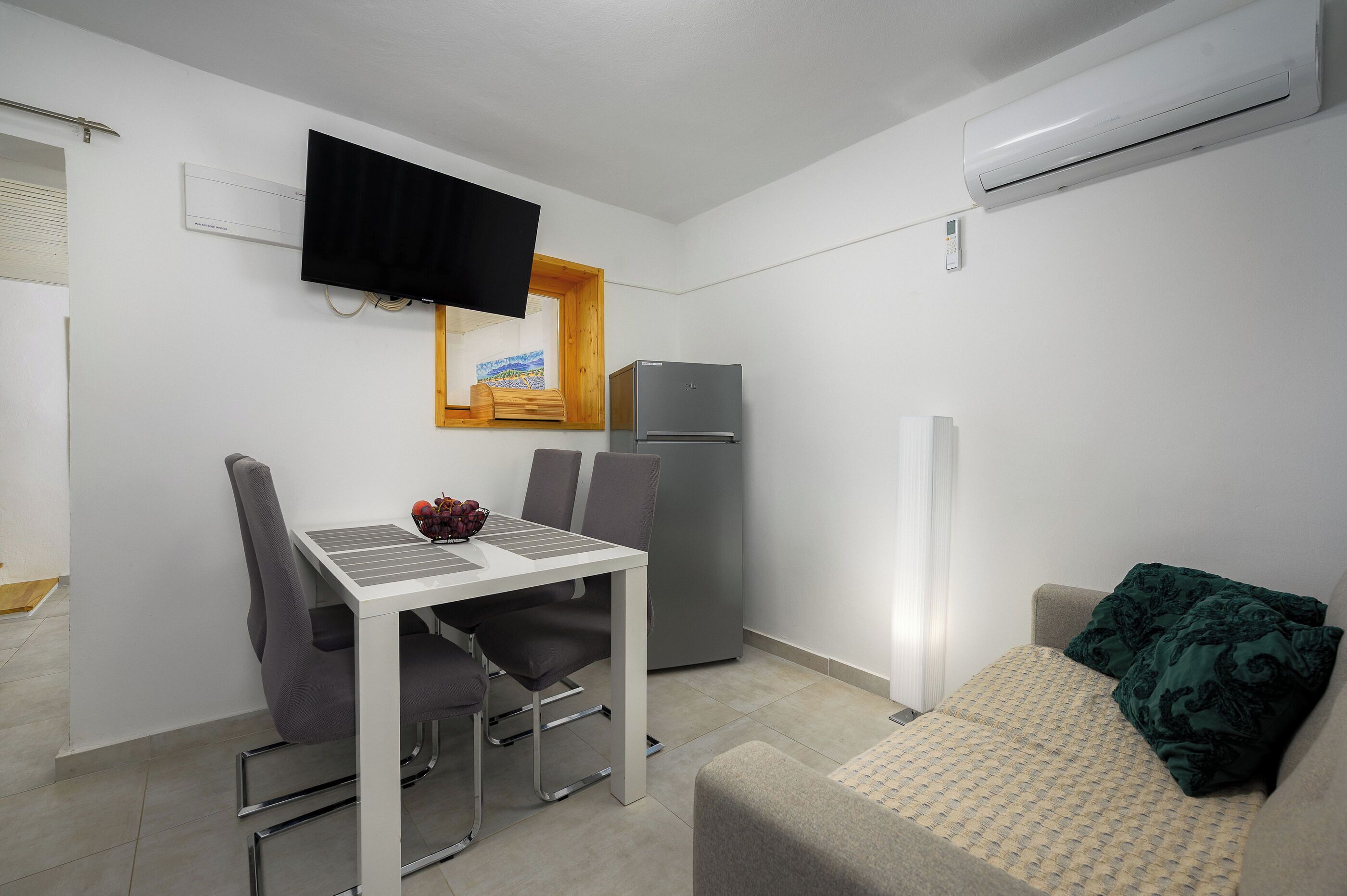 A compact living space with a kitchenette, a dining area, and a sofa.