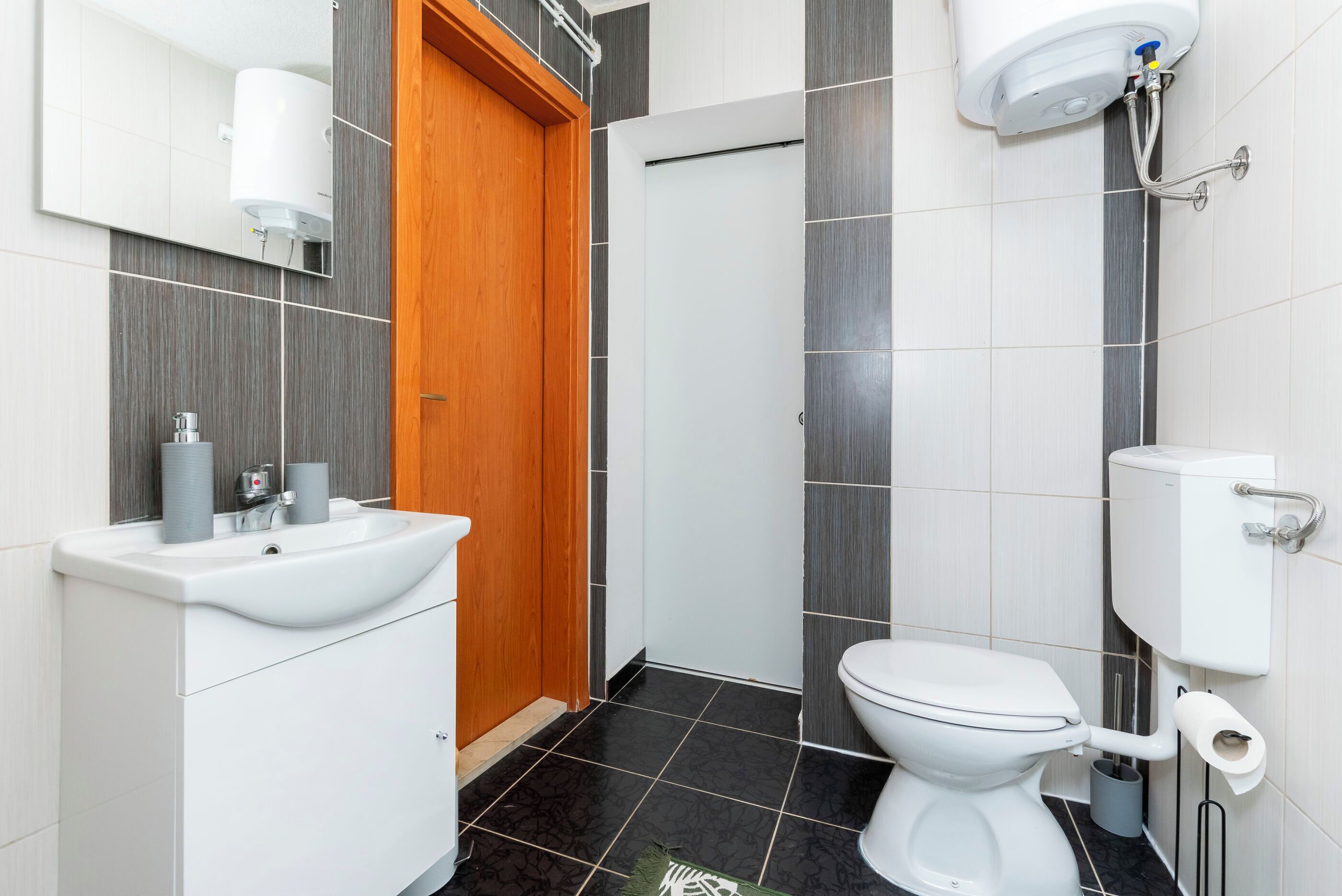 A modern bathroom with a sink, toilet, and shower.