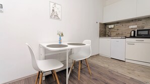 A modern kitchen with white cabinetry, a microwave, and a coffee maker. - Apartments Darinka (Vodice)
