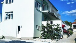 A two-story building with a balcony on the upper floor. - Apartments Marija (Rogoznica)