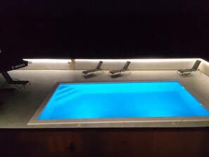 A rectangular indoor pool with four lounge chairs aligned along one side. - Apartments Marija (Rogoznica)