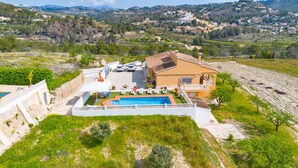 A Mediterranean-style villa with a swimming pool, outdoor seating, and a view of the surrounding countryside. - Villa Pastor - Plusholidays (Calpe)