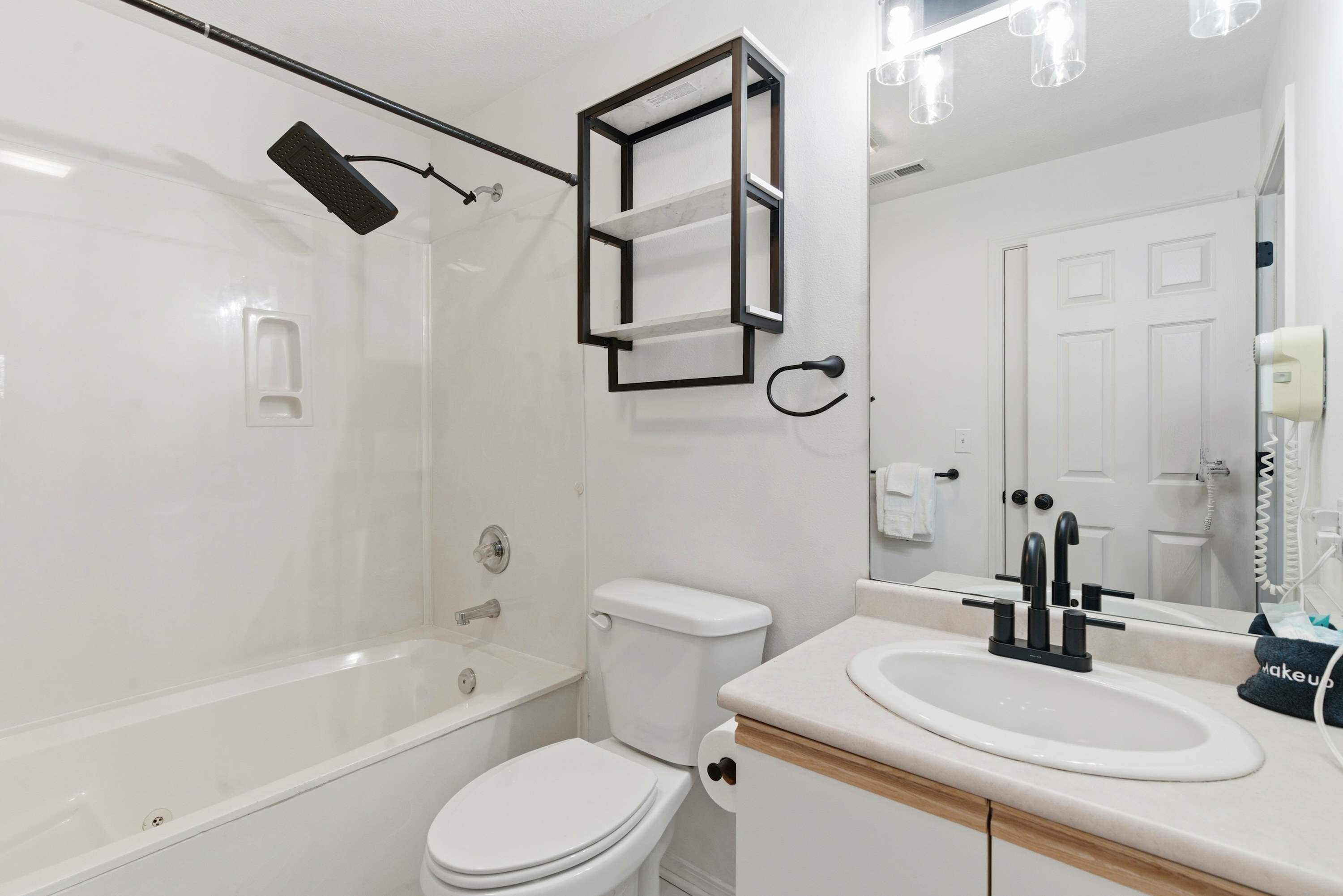 Et moderne badeværelse med badekar, toilet og vask.