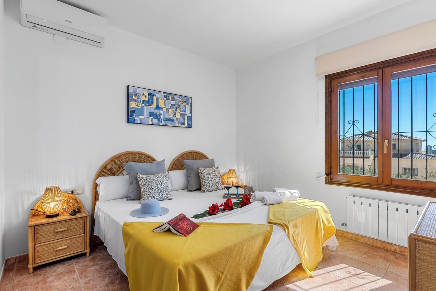 Une chambre à coucher avec un lit, des lampes de chevet, une fenêtre et un radiateur.