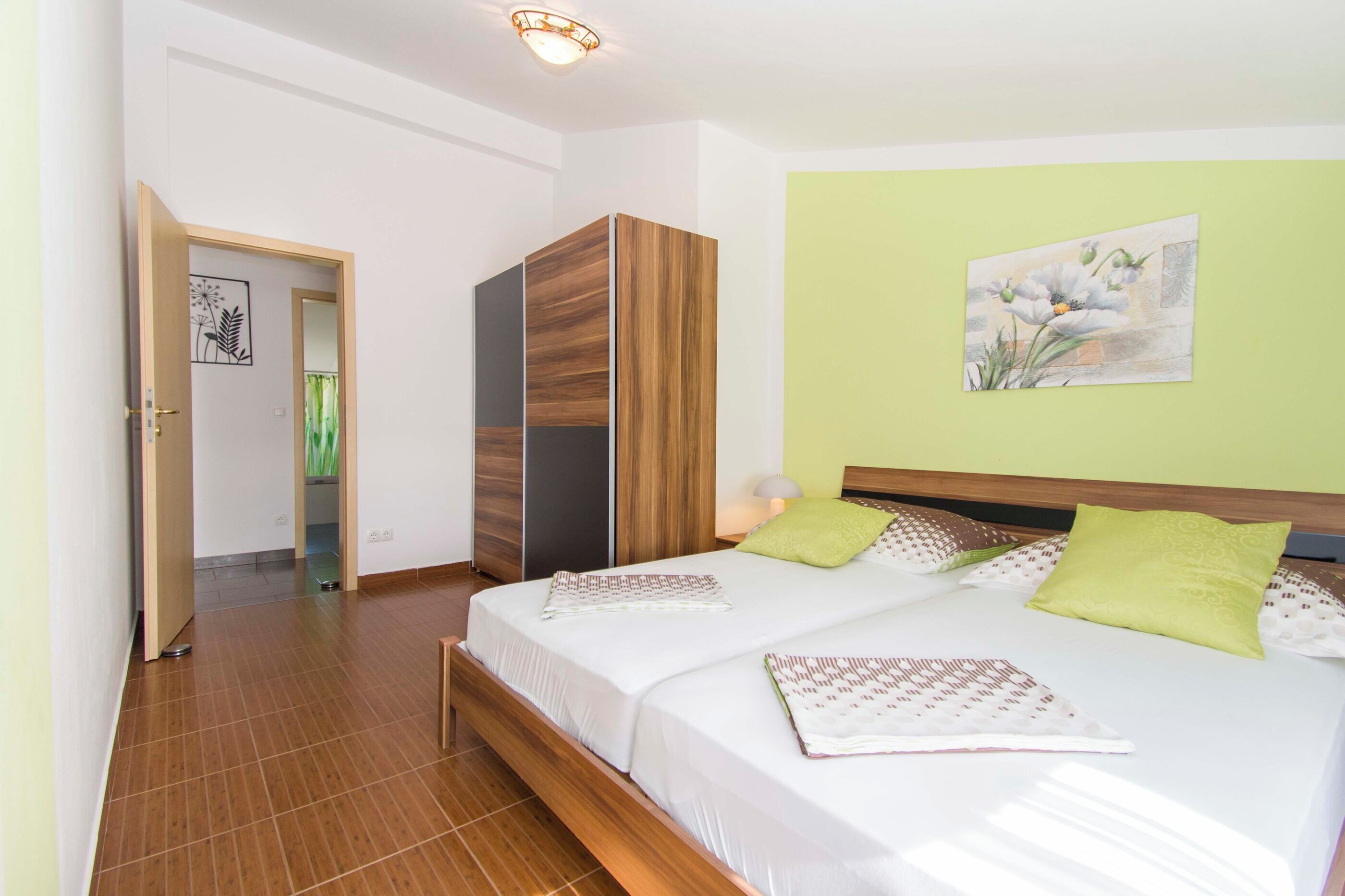 Un dormitorio con cama, armario y un cuadro en la pared.