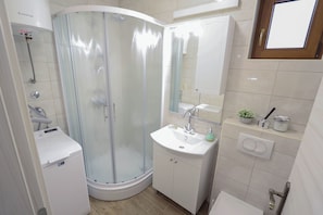 Apartamento (A1) | Banheiro | Chuveiro, toalhas de banho, shampoo, papel higiênico
