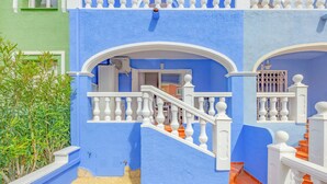 Un edificio azul con barandillas blancas y una escalera.