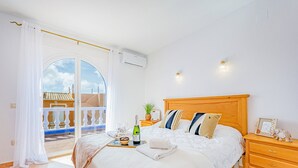 Un dormitorio con cama, mesita de noche y vistas al exterior.