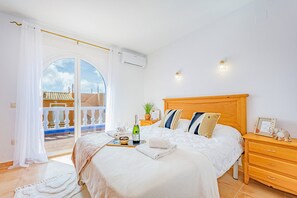 Ein Schlafzimmer mit Bett, Nachttisch und Blick ins Freie.