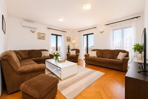 Ein modernes Wohnzimmer mit zwei Sofas, einem Couchtisch und einer TV-Konsole.