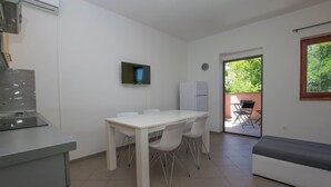 Een moderne keuken met een eethoek, een televisie en uitzicht op de omgeving.