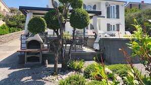 Une villa dotée d’un patio, d’un espace salon extérieur et d’une cheminée en pierre.
