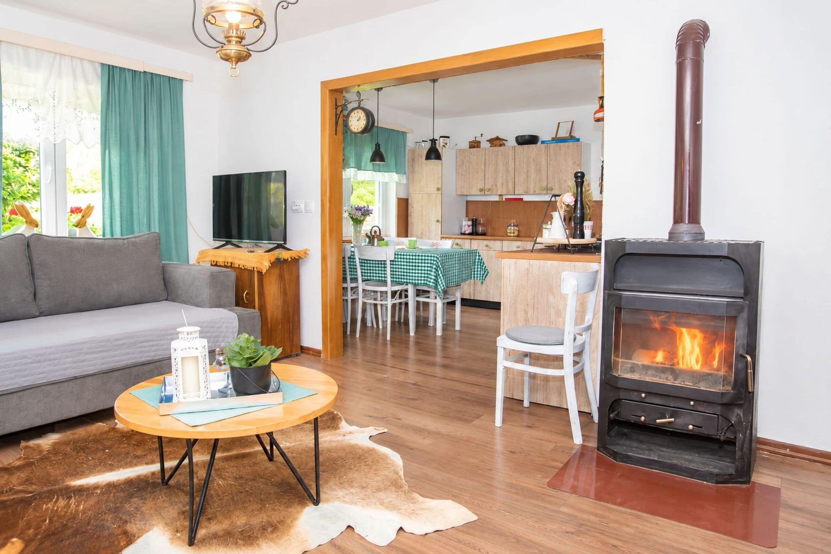 A living room with a sofa, a television, a coffee table with a plant, and a fireplace.