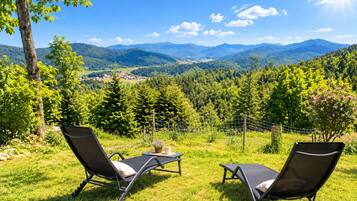 Dos sillones de relax mirando a un paisaje montañoso con cielo despejado.