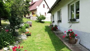 Una casa con un giardino curato, un vialetto lastricato e una facciata bianca.