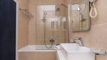 A modern bathroom with a glass-enclosed shower, a white bathtub, and a sink with a mirror.
