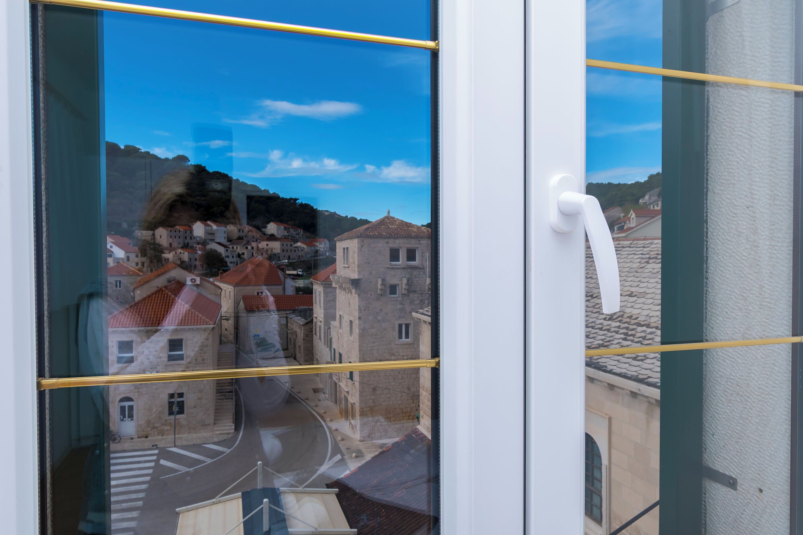 Une vue à travers une fenêtre dont le cadre est blanc et qui est traversée par une ligne horizontale jaune.
