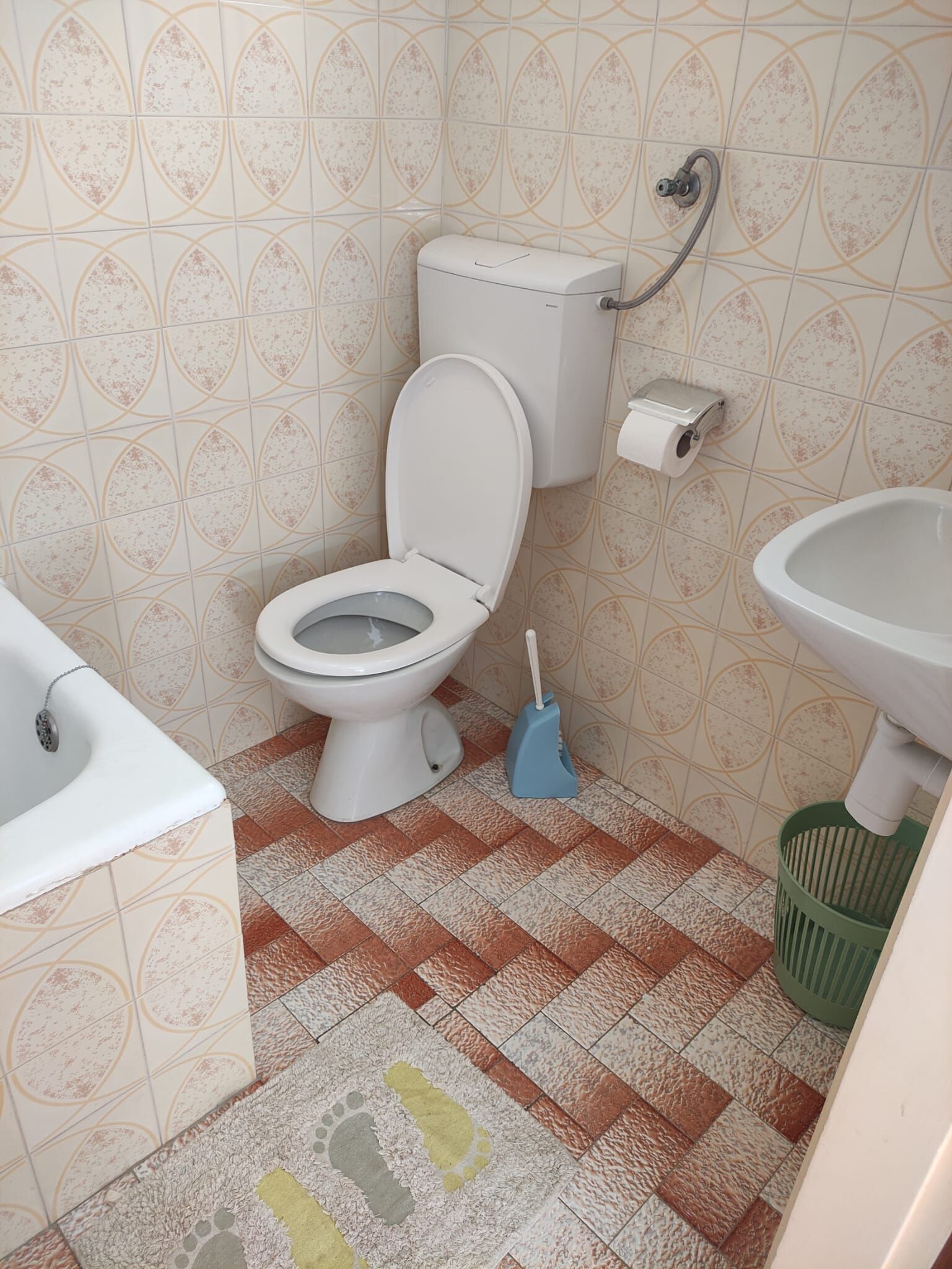 Egy fürdőszoba, amelyben WC, bidé, mosdókagyló és szemetes található.