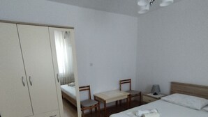 A bedroom with a bed, a desk, and a wardrobe. - Apartments Poldan (Rab)
