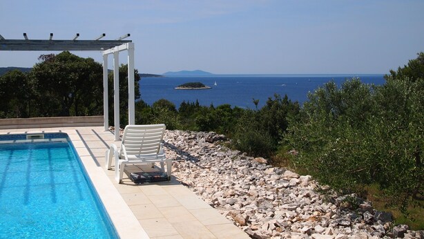 Ein Pool mit freiem Blick auf das Meer und ferne Inseln.