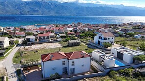 A coastal town with houses, a clear view of the sea, and mountains in the background. - Apartment Sankovic (Rovinj)