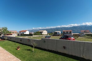 A residential area with houses, a concrete wall, and a view of mountains. - Apartment Sankovic (Rovinj)