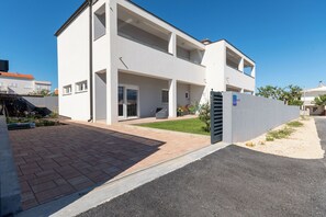 A modern two-story house with a paved driveway, a covered patio, and a small garden area. - Apartment Sankovic (Rovinj)