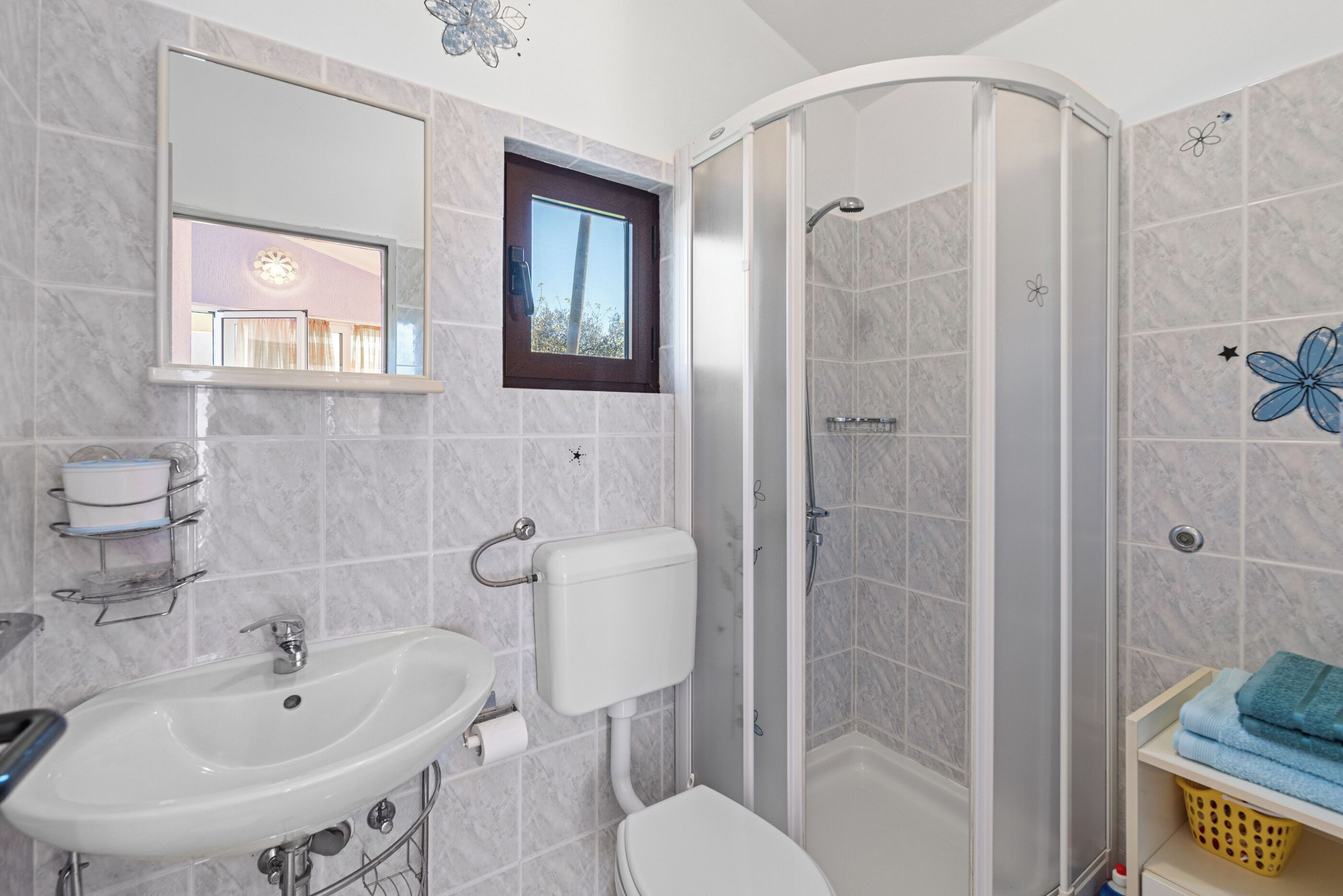 A bathroom with a sink, toilet, and shower.