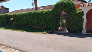 A house with a red roof, a brick chimney, and a gate covered by ivy. - Apartment Monte (Umag)