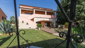 A two-story house with a stone facade, a central patio, and a well-maintained lawn. - Apartment Damjan (Kastelir-Labinci)