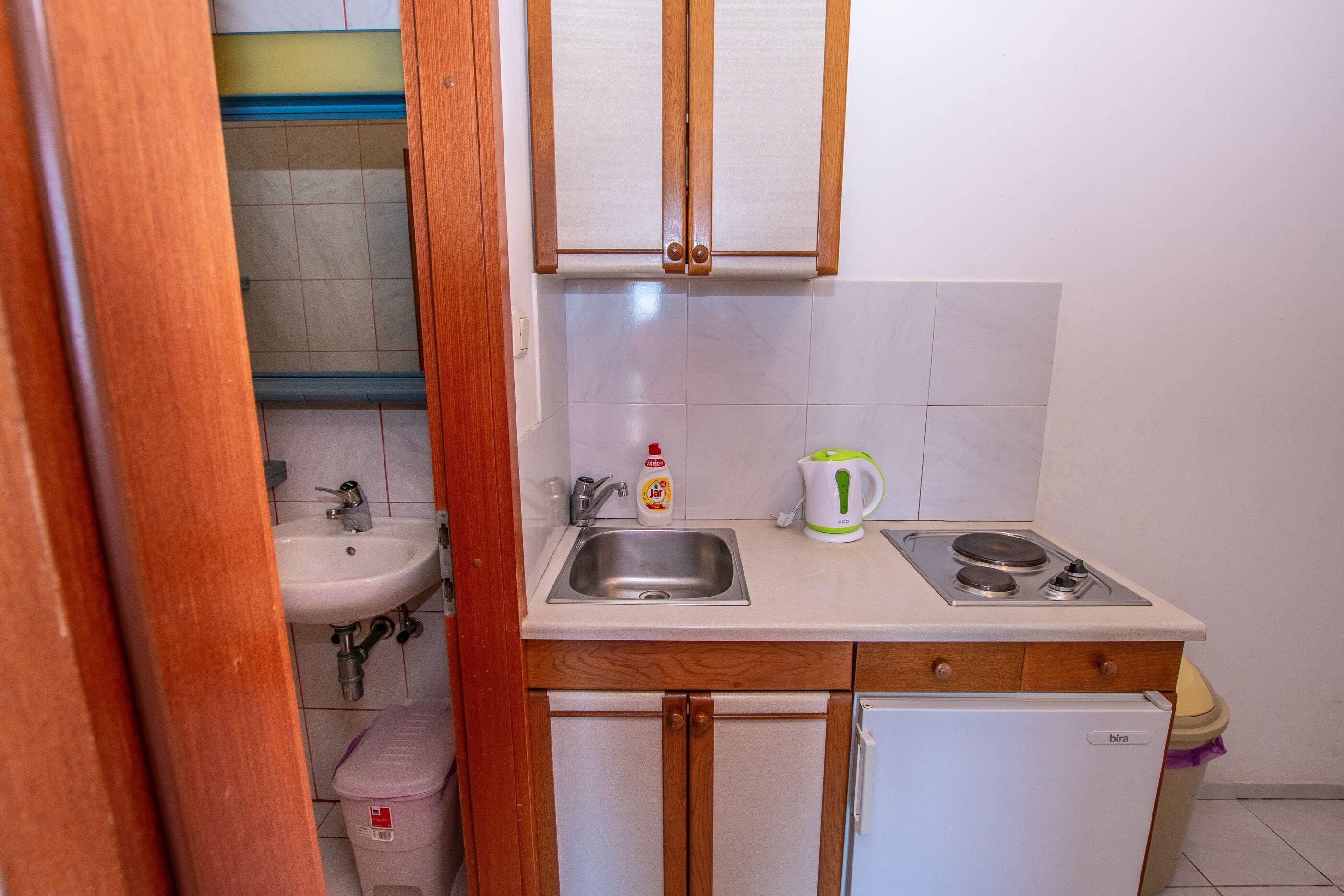 A compact kitchen with a sink, stove, and refrigerator.