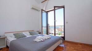 A bedroom with a bed, a nightstand, a window with a view, and a balcony. - Apartments Dalmatino (Biograd na Moru)