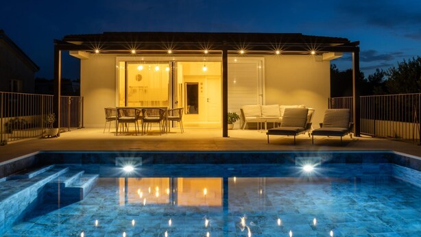 A covered outdoor area with a pool, seating, and a door leading to an interior space. - House Vrsinka (Marina)